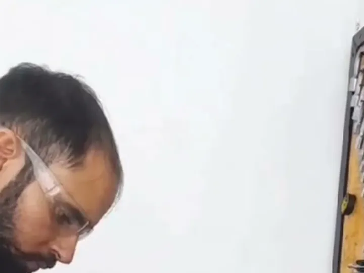 Técnico da Poti Bombas preparando peças na bancada da oficina
